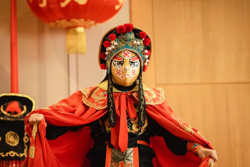 A masked performer in a red outfit.
