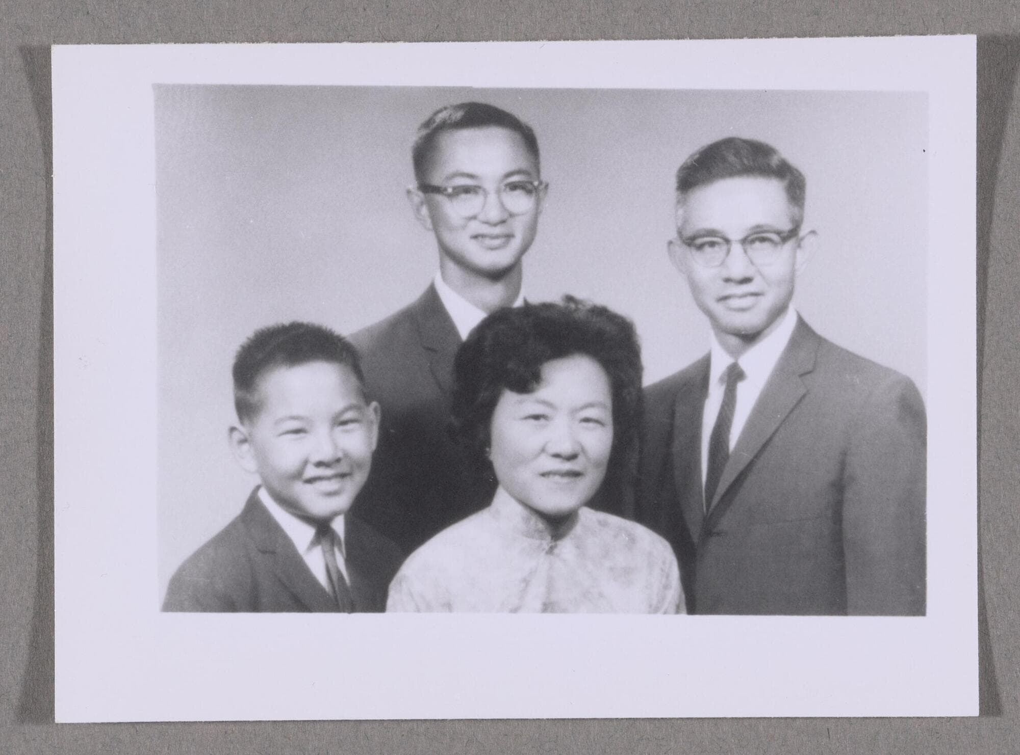 Formal family photograph of Chinese man and woman with two sons.