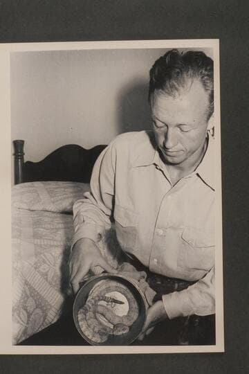 Lorin Bell. Taken in the Boulder Dam Hotel immediately following the Nevills first Grand Canyon run in 1938. He exhibits in the can a white rattlesnake which he caught somewhere along the river and kept as a pet for some time thereafter