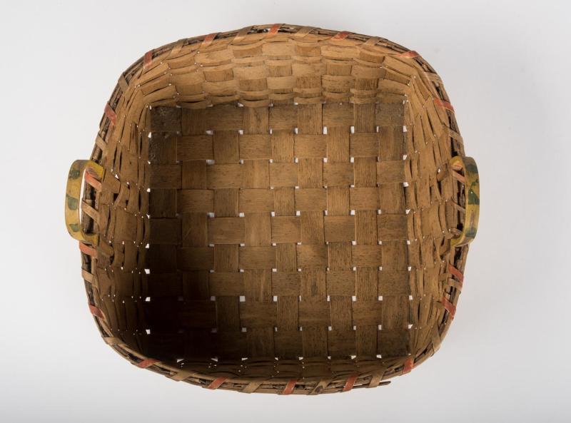 Overhead view into the interior of an oval-shaped splint woven basket with handles.