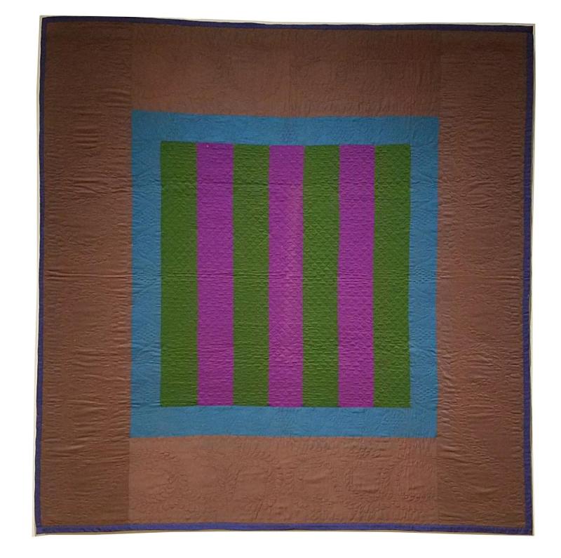 Slate grey quilt made from fabric with a square in the center containing purple and green stripes with a blue border around the stripes.  