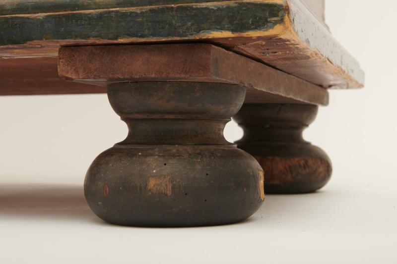 Close-up view of the feet of a large wooden wardrobe.