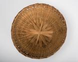 Underside of woven lid of brown basket showing the structure formed with strips of ash wood.