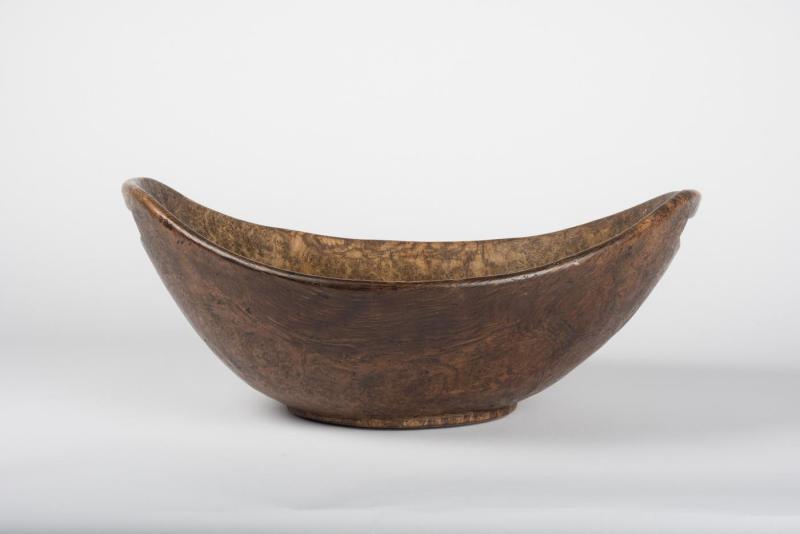 Bowl made from dappled burl wood with curved, U-shaped rim and cutout handles.