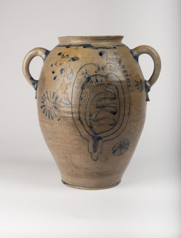 Back view of ovoid jar with handles near top, decorated with blue pigment and incised decorations, many illegible, with a heart shape filled with squiggly lines at the center.