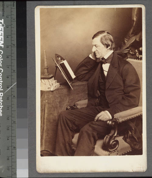 Portrait of Ralph Waldo Emerson seated, left profile, reading a book.