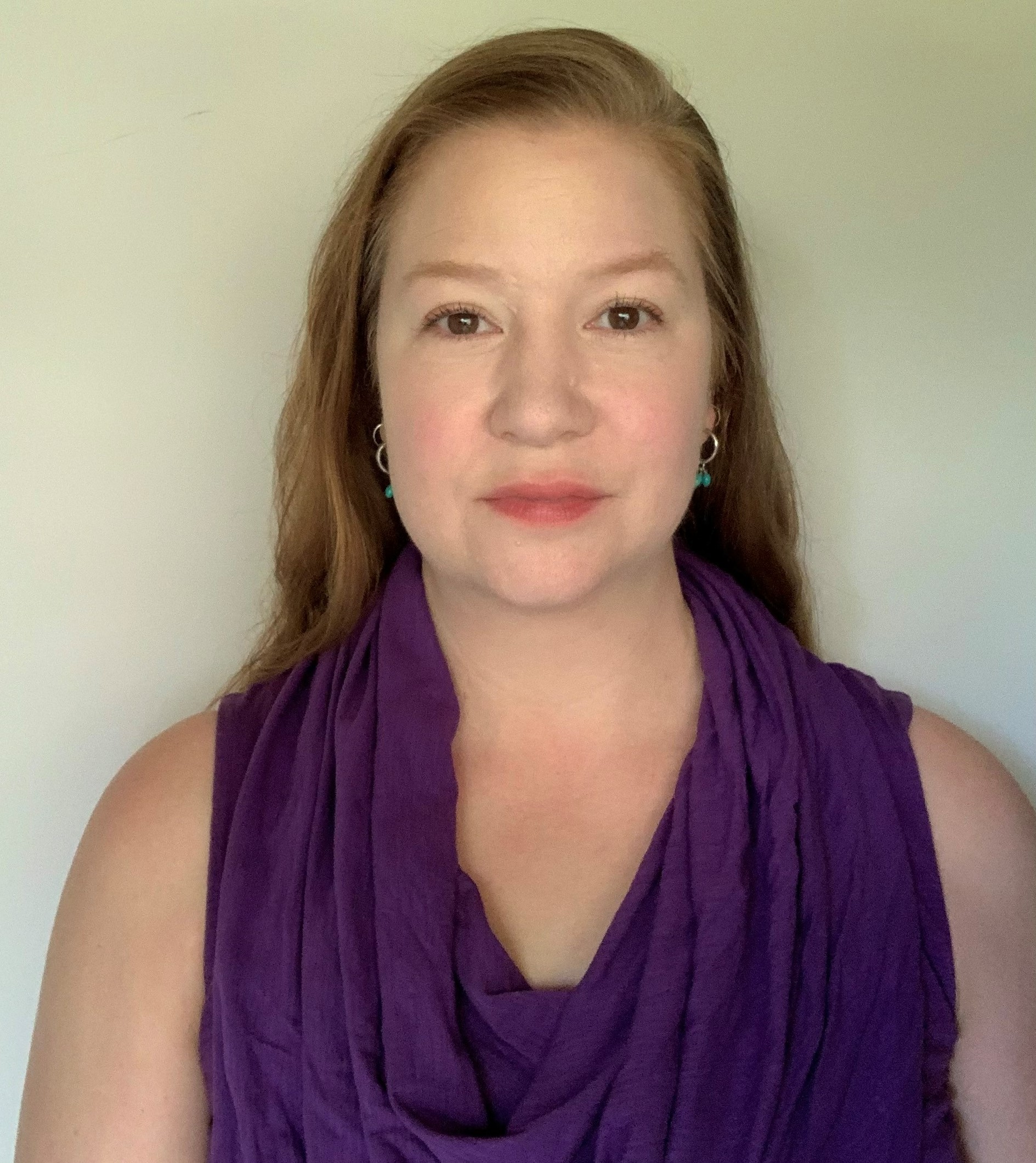 White woman in a dark shirt against a white background