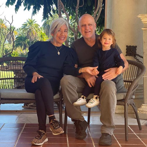 A family sits on a bench together.