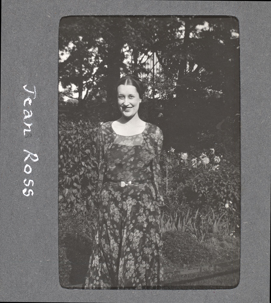 Black-and-white photo of a young woman standing in a garden. "Jean Ross" is written in the photo margin.