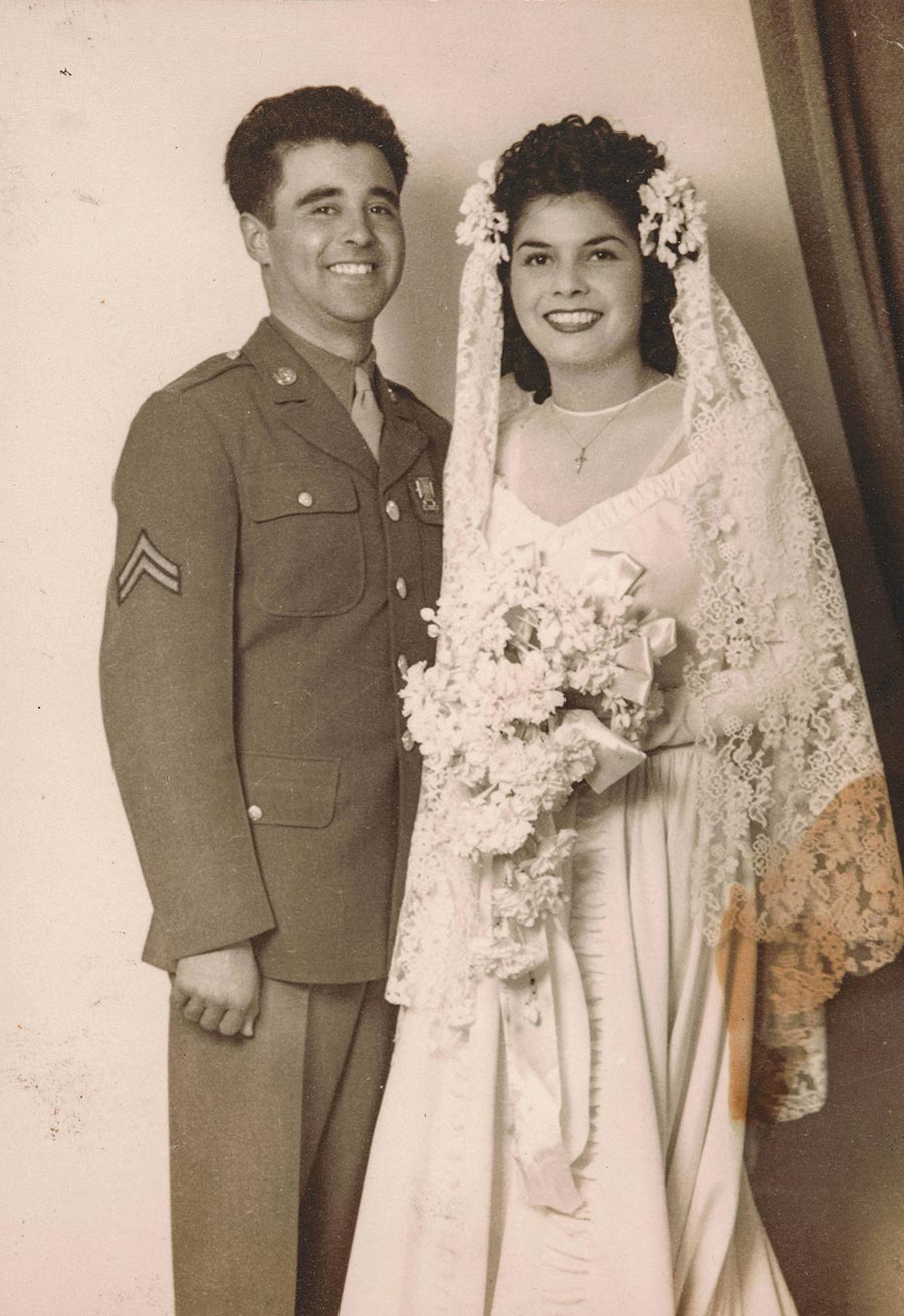 A black-and-white photograph of a man in a military uniform and a woman in a white wedding dress.