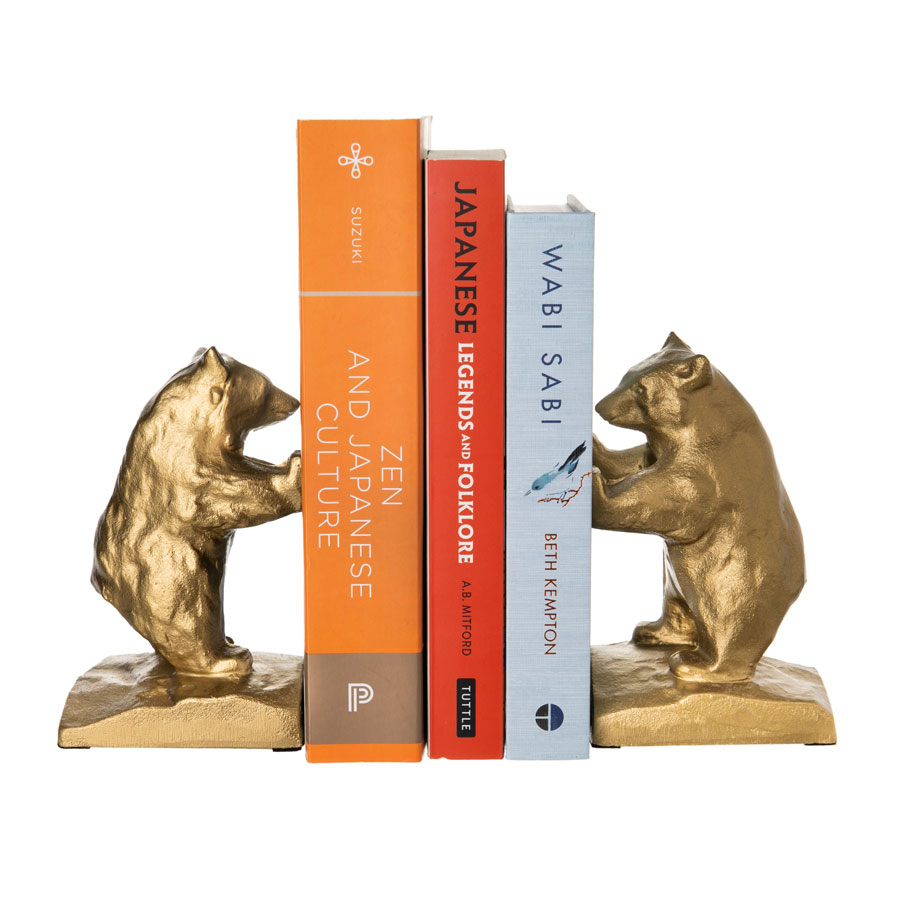 Two metal bear-bookends hold up three books.