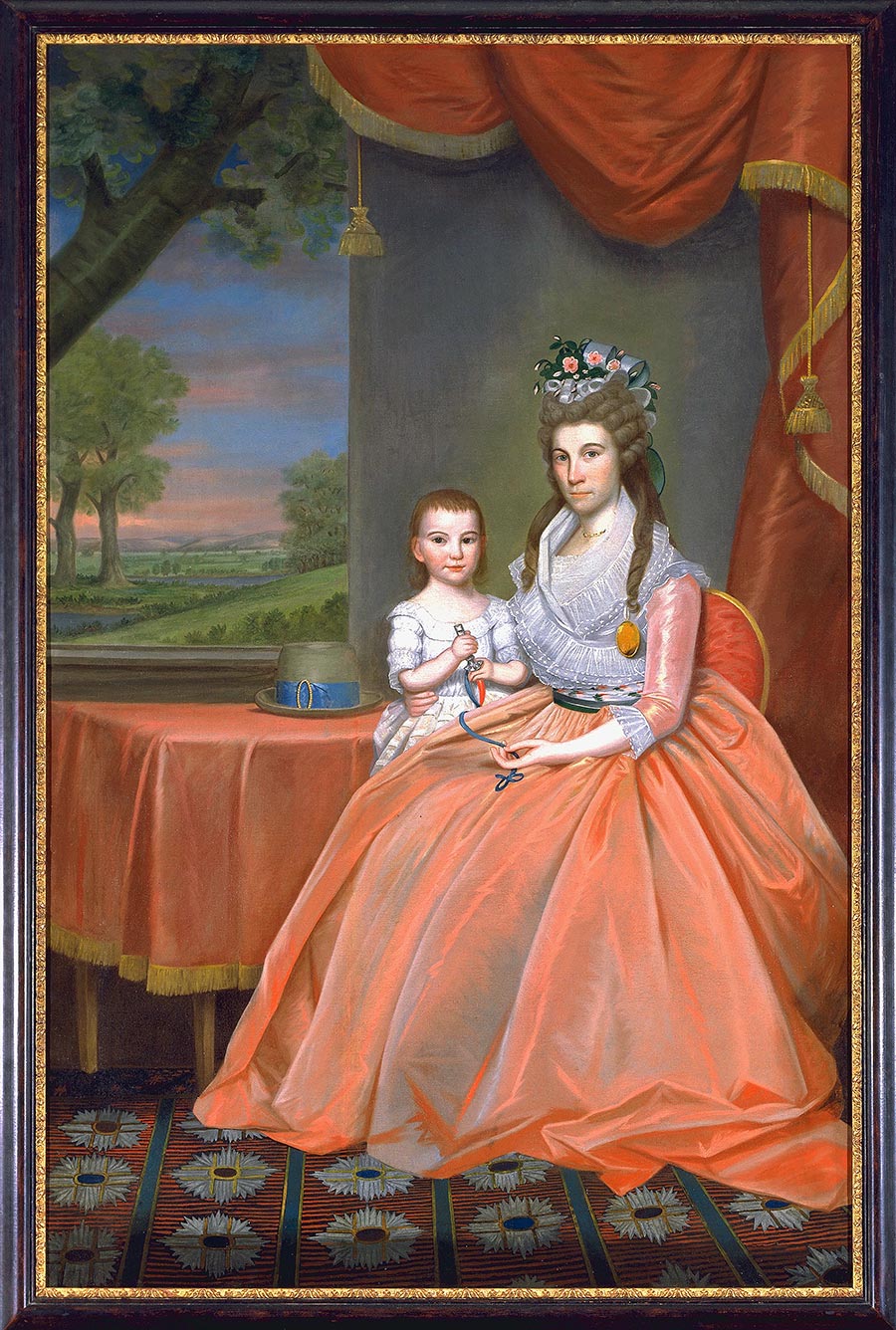 A portrait of a woman sitting with a young boy. Her dress, a tablecloth, and a curtain are all in coral red.