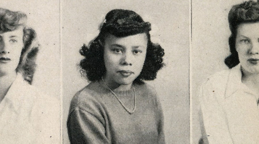 A school yearbook photo of a person with short curly hair.