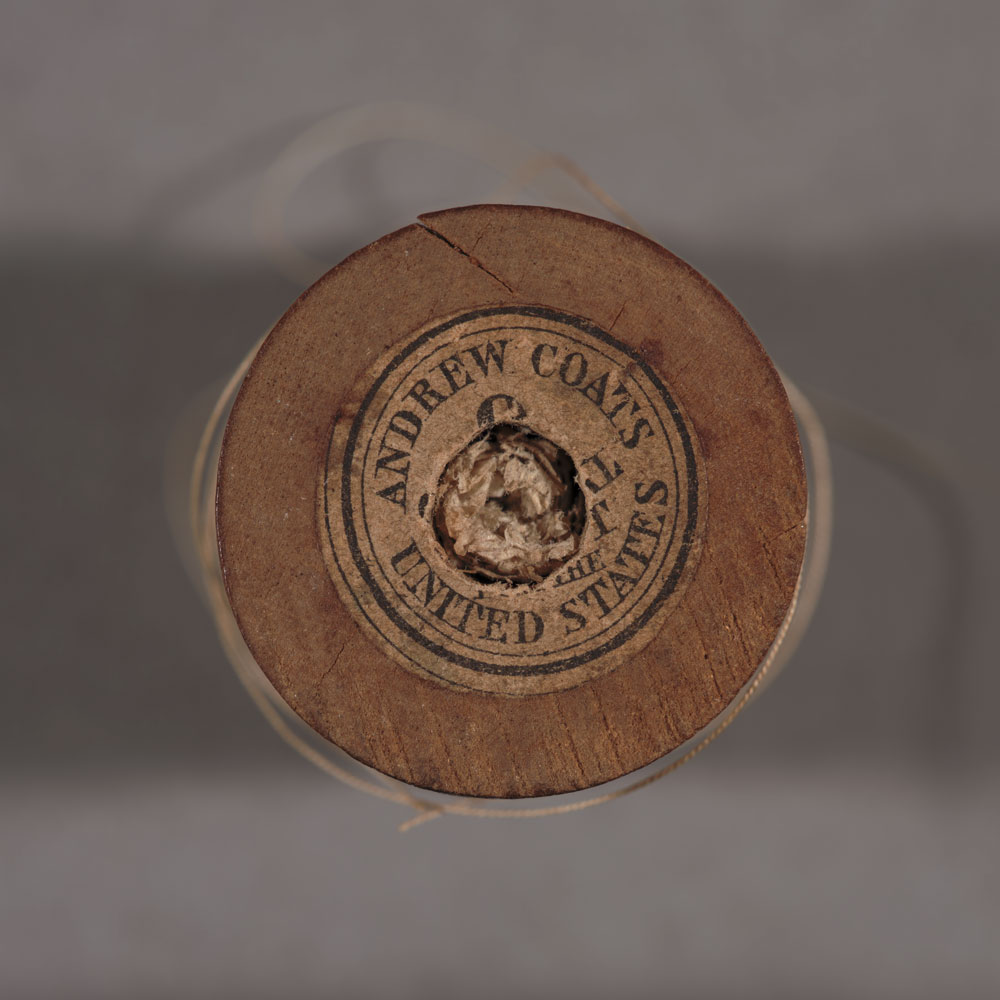 View of a spool of thread from above. The text on the label reads “Andrew Coats United States.”