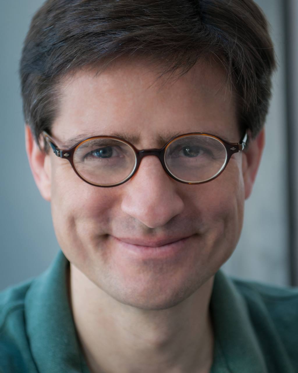 headshot of man wearing glasses with short brown hair