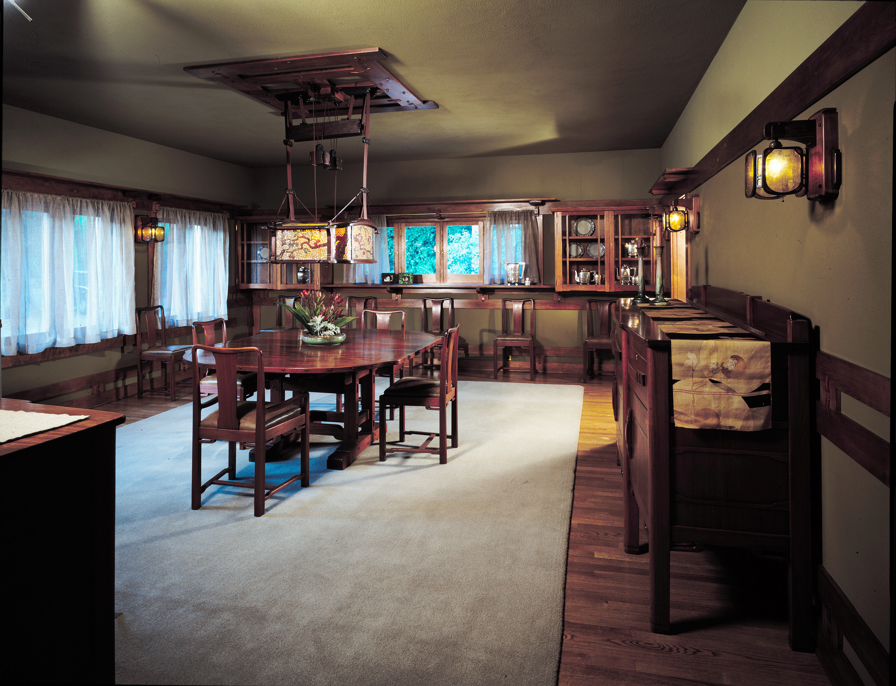 A dining room in a craftsman-style home, with taupe-colored walls and wood furniture.