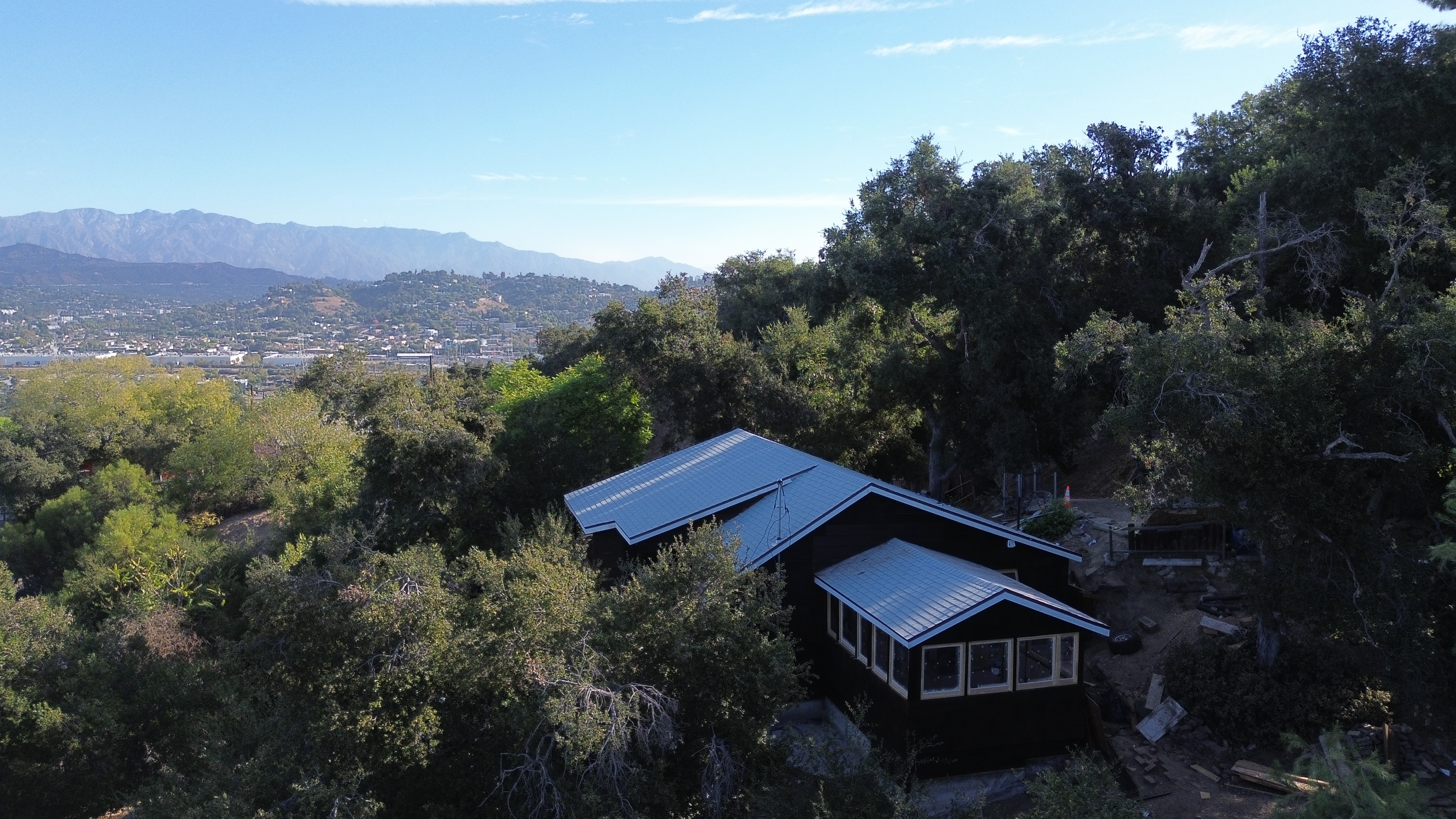 aerial view of a home on a hill surrounded by trees.