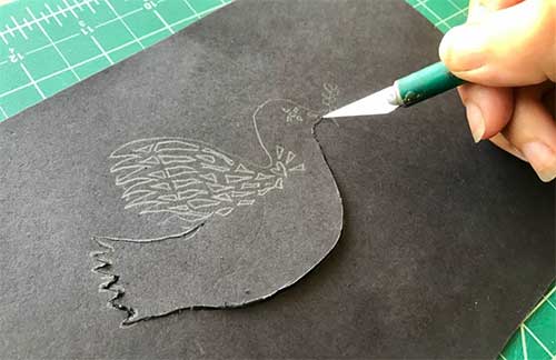 Cutting out dove shadow puppet