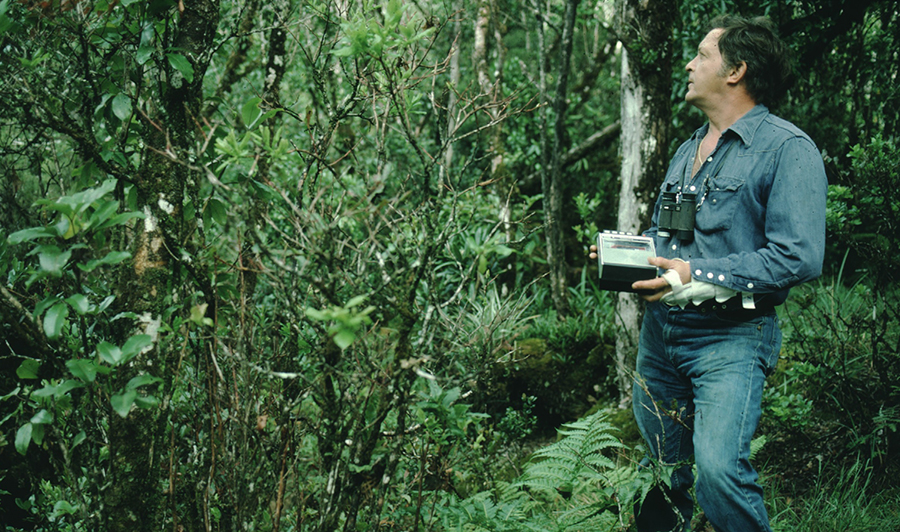 Field biologist John Sincock in the forest with a tape recorder