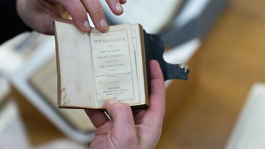 Olga Tsapina holds a small edition of the New Testament that Zachariah Shugart carried around in his pocket. Photograph by Aric Allen.