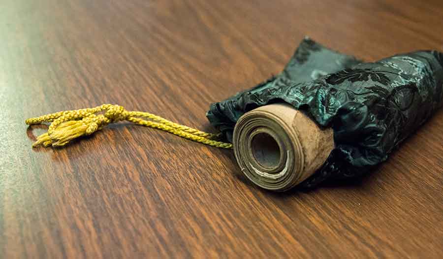 In the Middle Ages, the tiny roll was most likely carried in a leather pouch. For several decades, however, it has been kept in this Victorian silk purse with golden drawstrings. Photograph by Kate Lain.