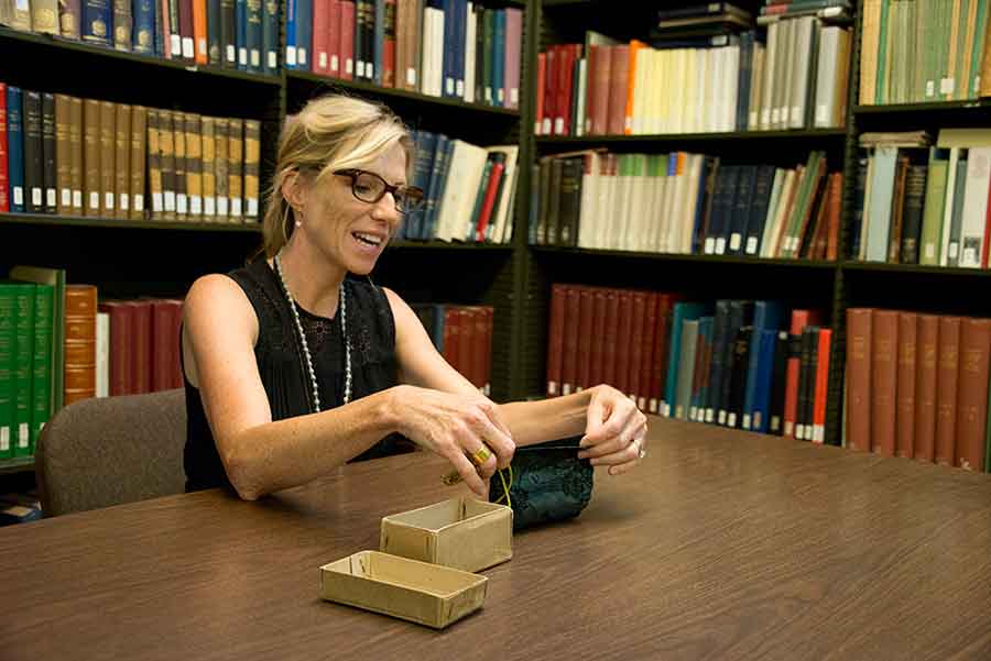 Andrea Denny-Brown, former Andrew W. Mellon Foundation Fellow at The Huntington, holds the silk purse that contains the arma Christi manuscript. Photograph by Kate Lain. 