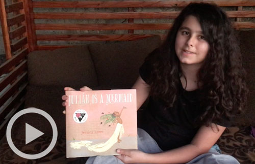 Girl holding Julián is a Mermaid book