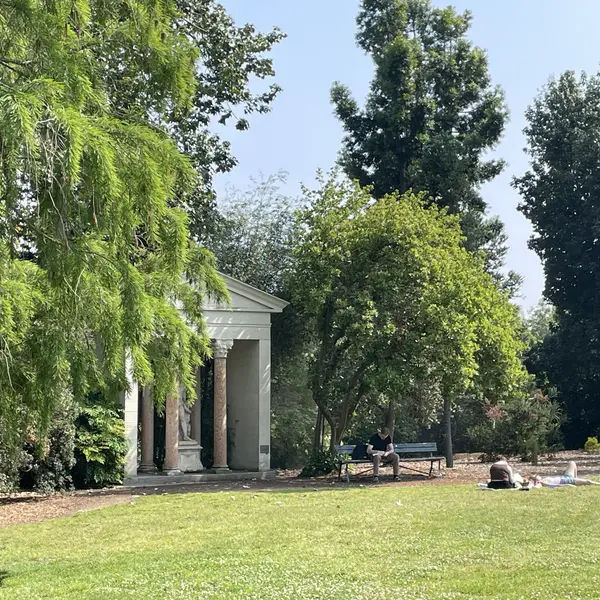 Visitors relax in front of a stone structure in the Australian Garden.