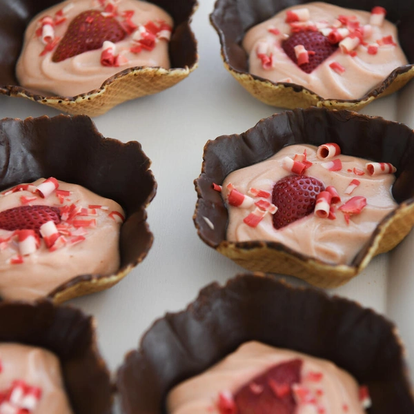 Small pastries with pink cream filling and strawberries.