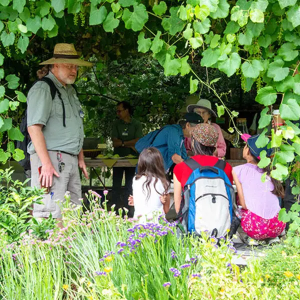 Master gardener volunteer Roger Gray talks with children in the Ranch Garden