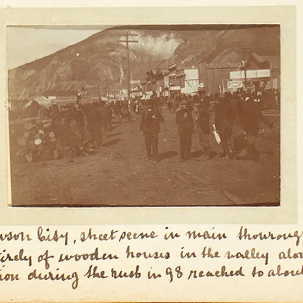 Detail of a page from Alfred and Charles O’Meara’s photograph album showing a street scene in the bustling boomtown of Dawson City, June 1899