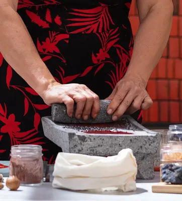 woman's hands grinding seeds for dye