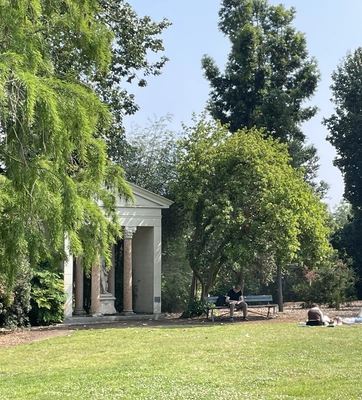 Visitors relax in front of a stone structure in the Australian Garden.