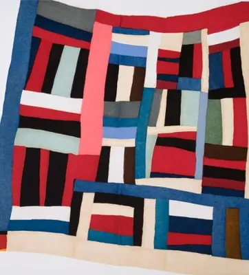 An aquatint print of a geometric quilt in various blue, red, and beige rectangles.