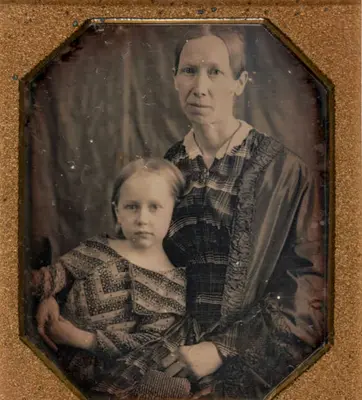 A framed black and white photo of a woman and young girl.