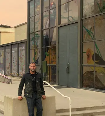 Artist Enrique Martínez Celaya stands in front of his art installation on the glass walls of the Virginia Steele Scott Gallery.