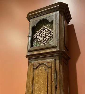 The face of an old grandfather clock has been replaced with a cosmogram symbol.