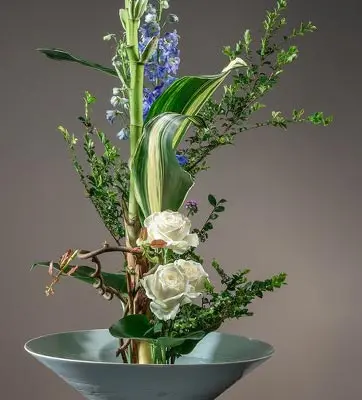 A traditional Chinese Floral Arrangement, with upright greenery and white roses.