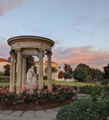 A tempietto in a rose garden at dusk.