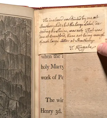 An open book with layers of papers on the same page, including an illustration and printed and handwritten text.