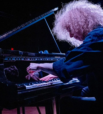 A stylized photo of a musician playing a piano.