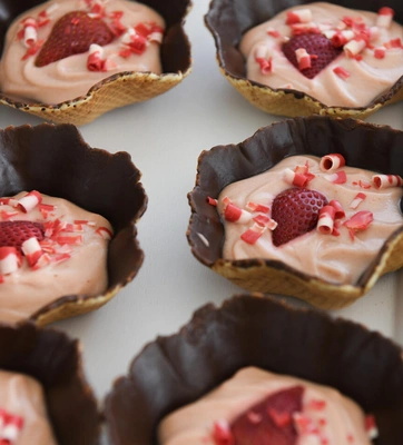 Small pastries with pink cream filling and strawberries.