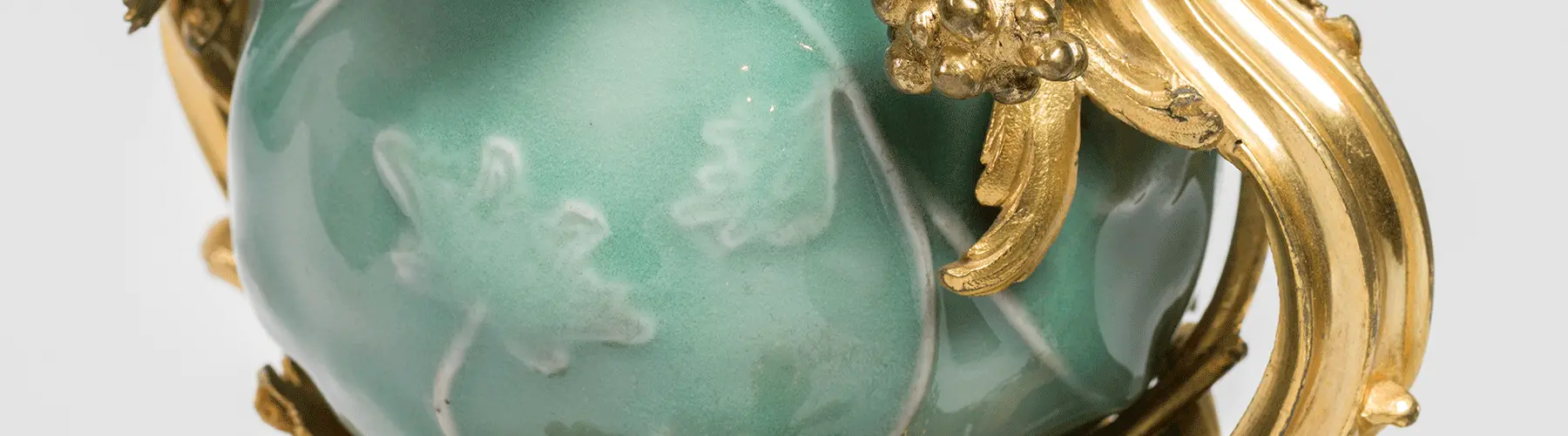 close up of green jade vase with gold details