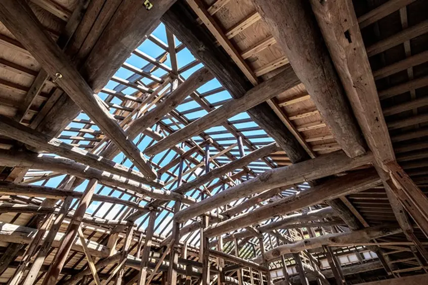 The original roof beams were used in the reconstructed framework of the house. 