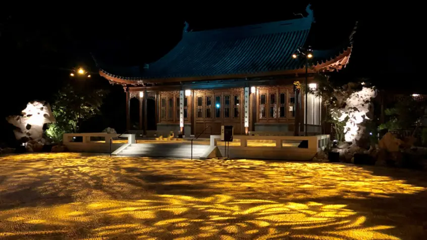 Gold-pattern floral patterns light up a Chinese courtyard at night.