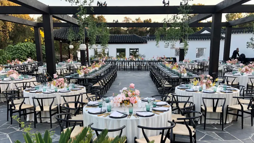 Tables set up under an open wooden canopy.