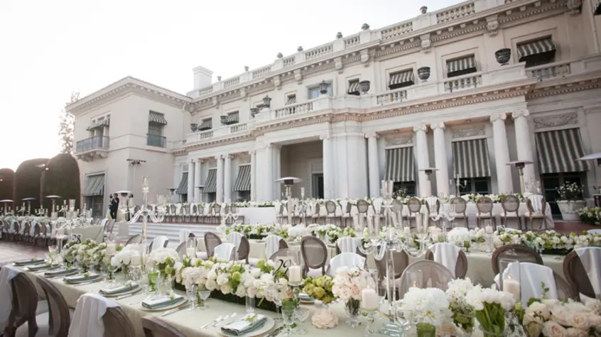 White tablecloths and tan chairs for an event.