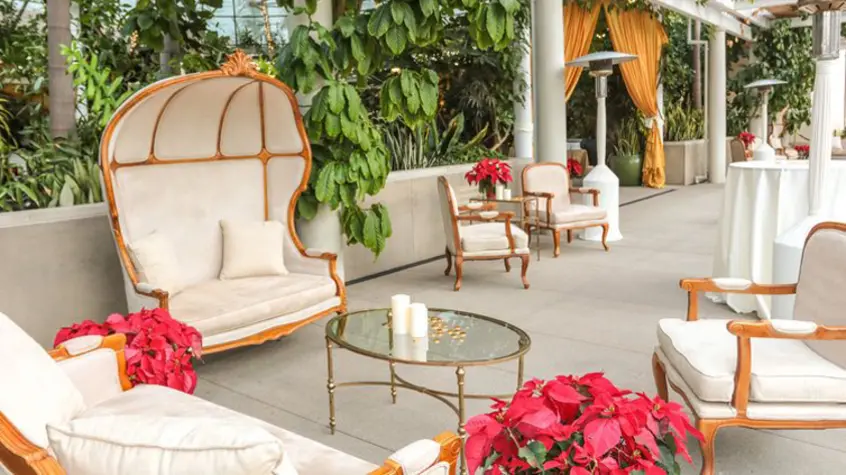 Carribean-inspired chairs and love couches are accented by poinsettia plants.