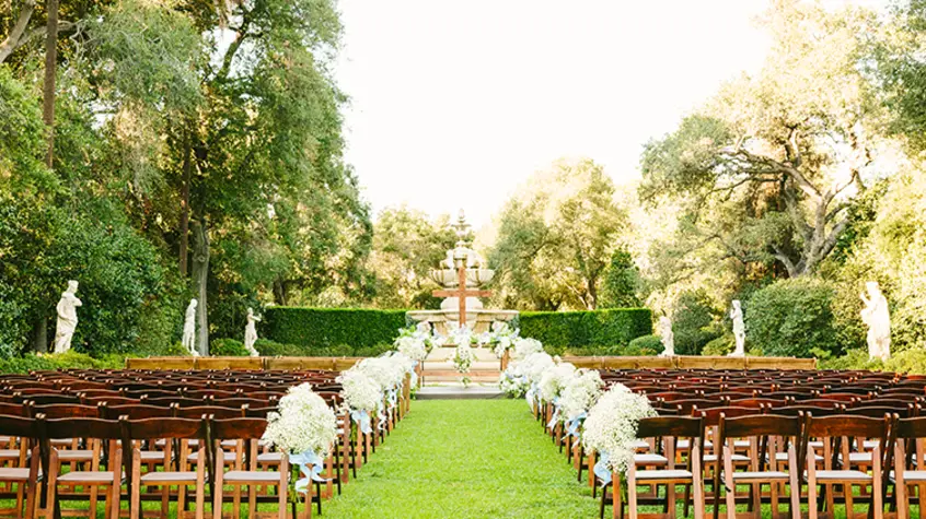 Rows of chairs set out wedding ceremony-style with a large fountain in the background.