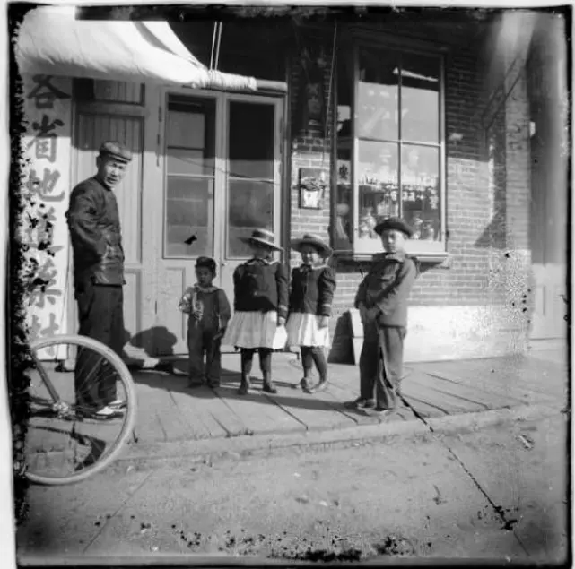 Man and four children outside store, Kwong On & Co., address number 432.